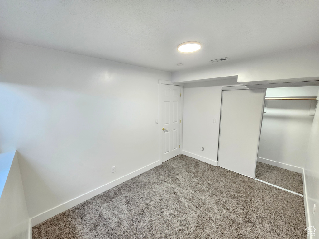 Unfurnished bedroom with carpet flooring, baseboards, and a closet