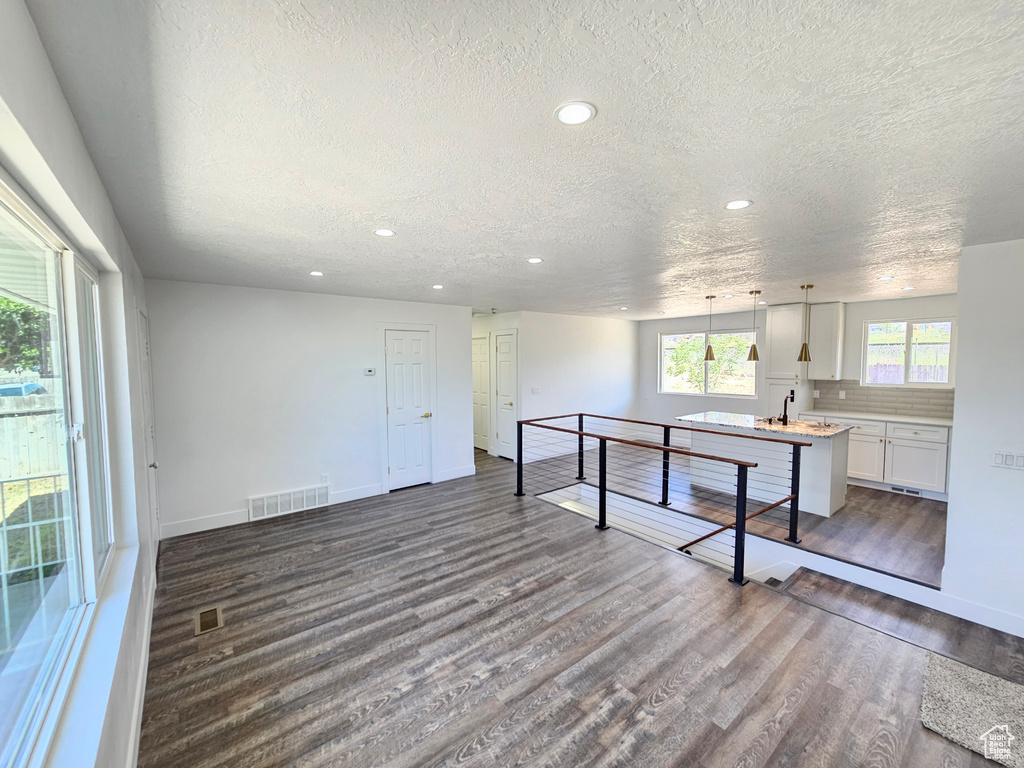 Kitchen featuring a textured ceiling, dark wood-style flooring, recessed lighting, light countertops, and white cabinetry