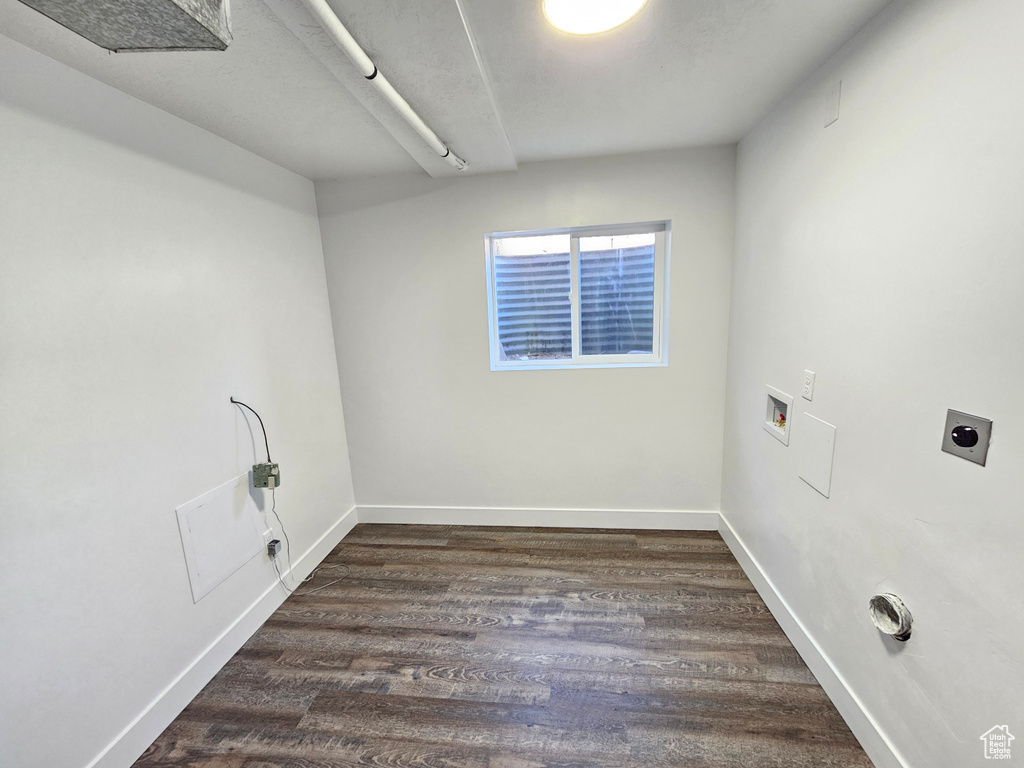 Washroom with hookup for a washing machine, wood finished floors, electric dryer hookup, and baseboards