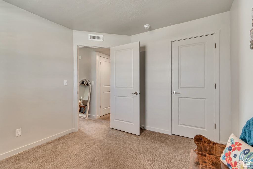 Living area with light carpet and baseboards
