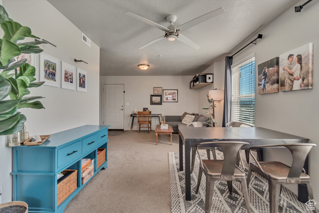 Carpeted dining area with a ceiling fan