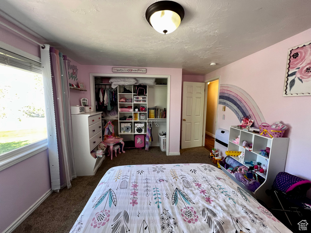 Carpeted bedroom featuring a closet and baseboards