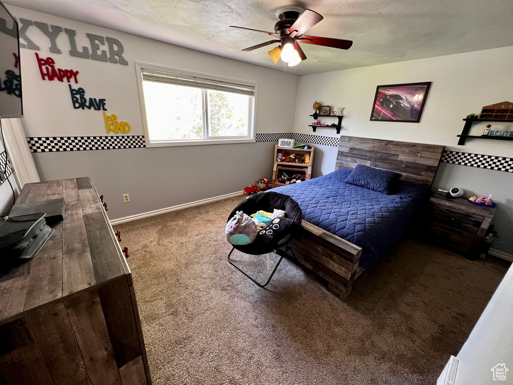 Bedroom featuring carpet floors, baseboards, and ceiling fan