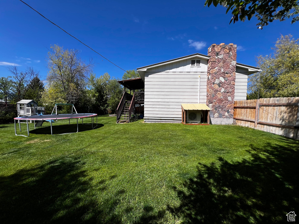 View of yard featuring a trampoline and stairway