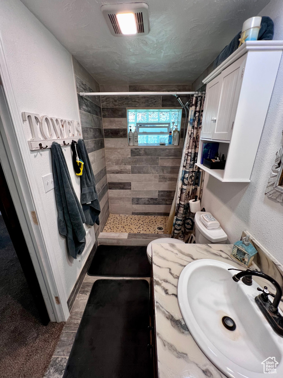 Bathroom featuring a stall shower, vanity, and toilet
