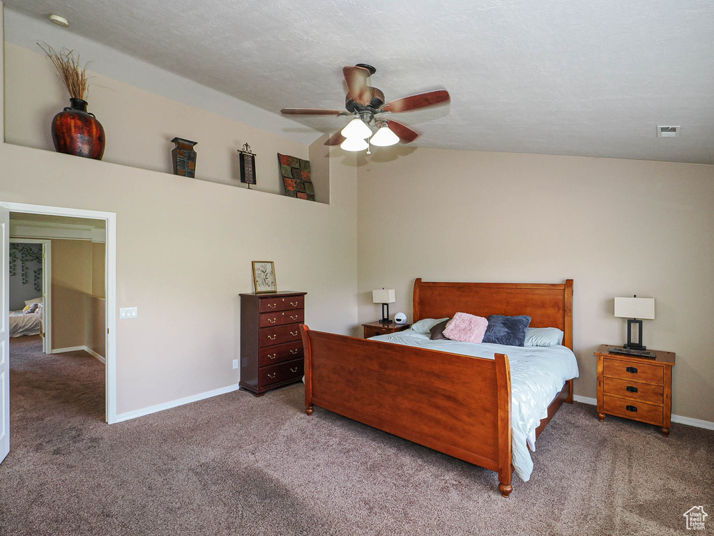 Carpeted bedroom with baseboards, a ceiling fan, and lofted ceiling