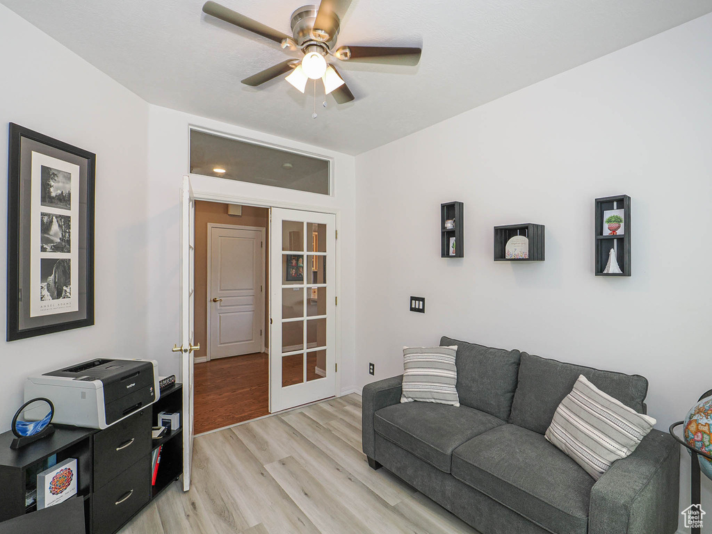 Living area with french doors, light wood-type flooring, and ceiling fan