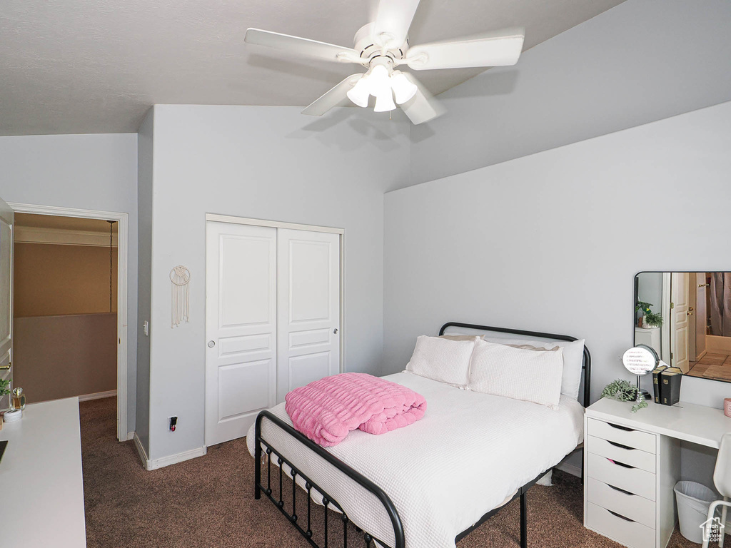 Bedroom with carpet, a closet, a ceiling fan, vaulted ceiling, and baseboards