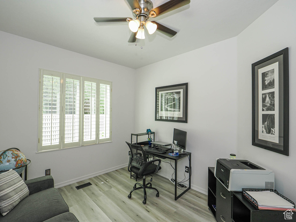 Office space featuring light wood finished floors, a ceiling fan, and baseboards