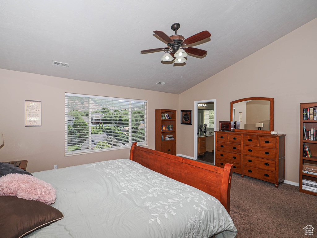 Carpeted bedroom with vaulted ceiling, a ceiling fan, and baseboards