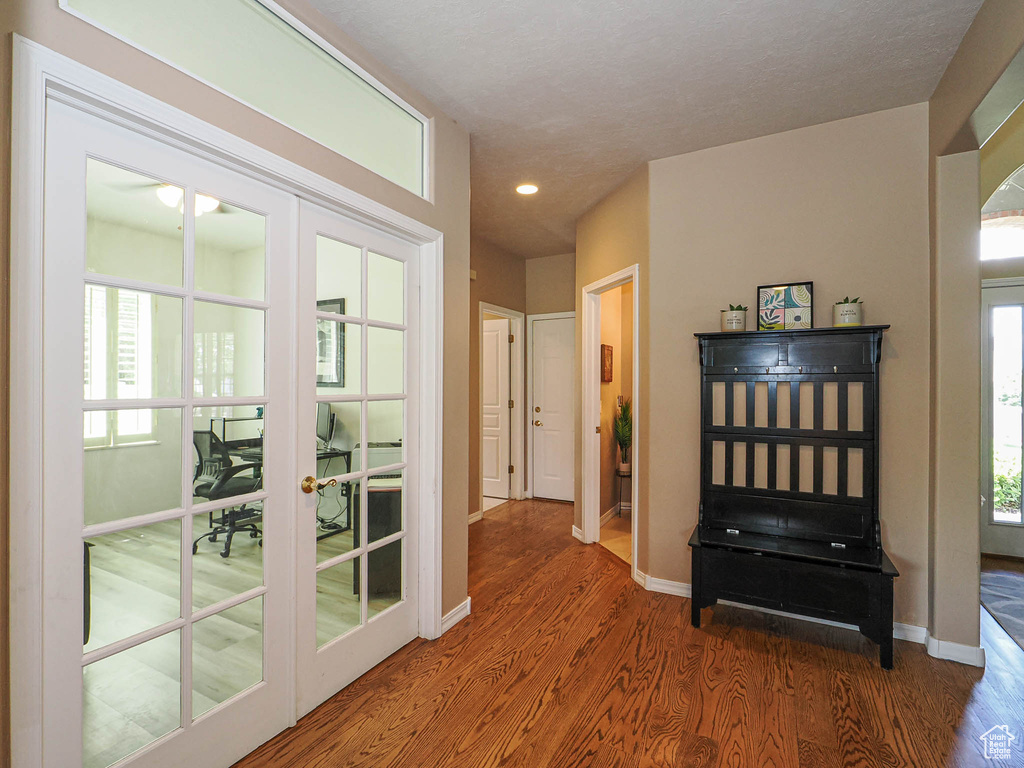 Hallway with wood finished floors, baseboards, recessed lighting, and french doors