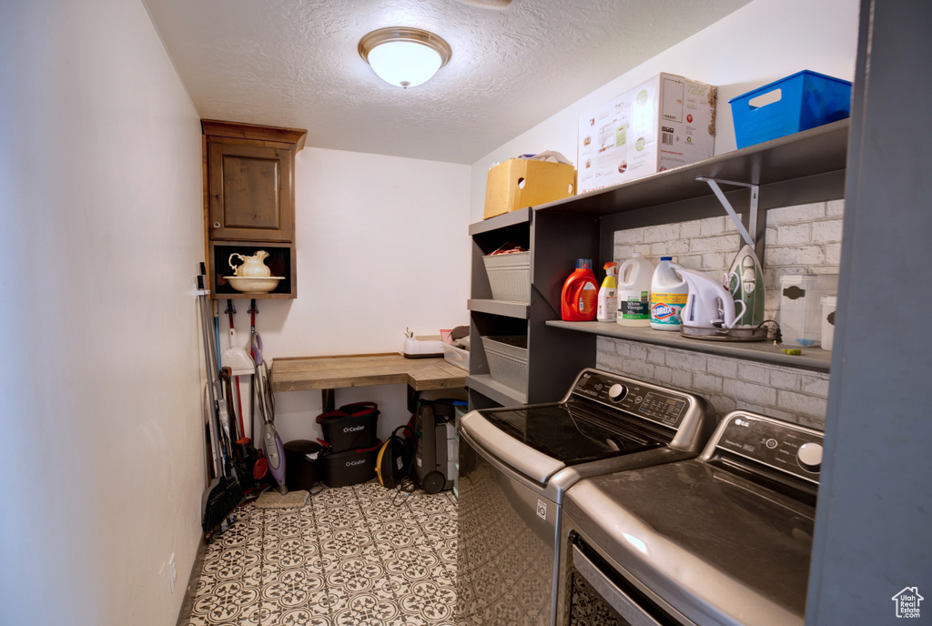 Washroom featuring separate washer and dryer, a textured ceiling, and baseboards