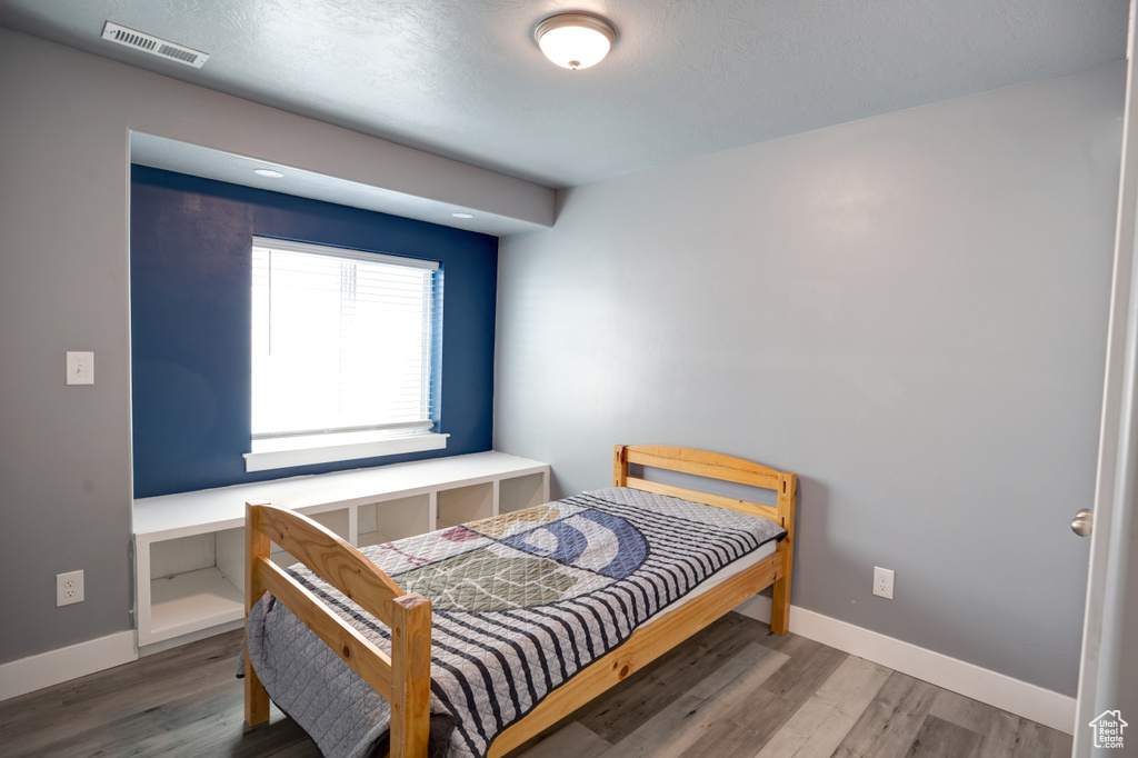 Bedroom featuring wood finished floors and baseboards