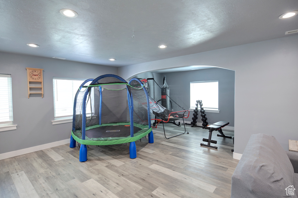 Playroom with recessed lighting, arched walkways, baseboards, and wood finished floors