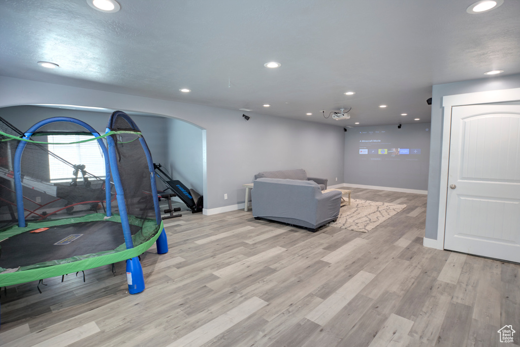 Playroom featuring recessed lighting, baseboards, light wood finished floors, and arched walkways