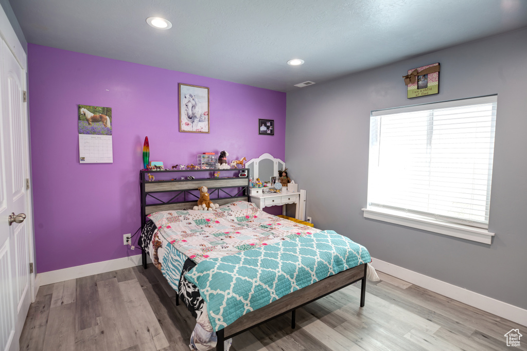 Bedroom with baseboards, wood finished floors, and recessed lighting