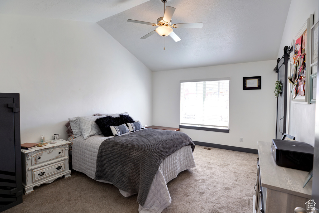 Bedroom with lofted ceiling, carpet floors, and ceiling fan