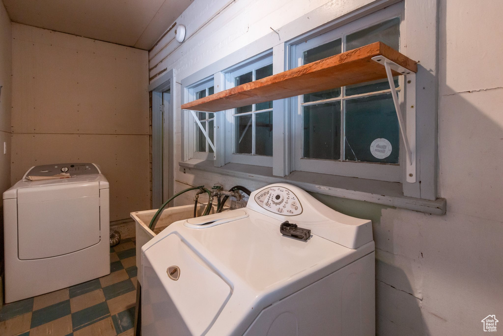 Laundry room featuring tile patterned floors and washer and clothes dryer