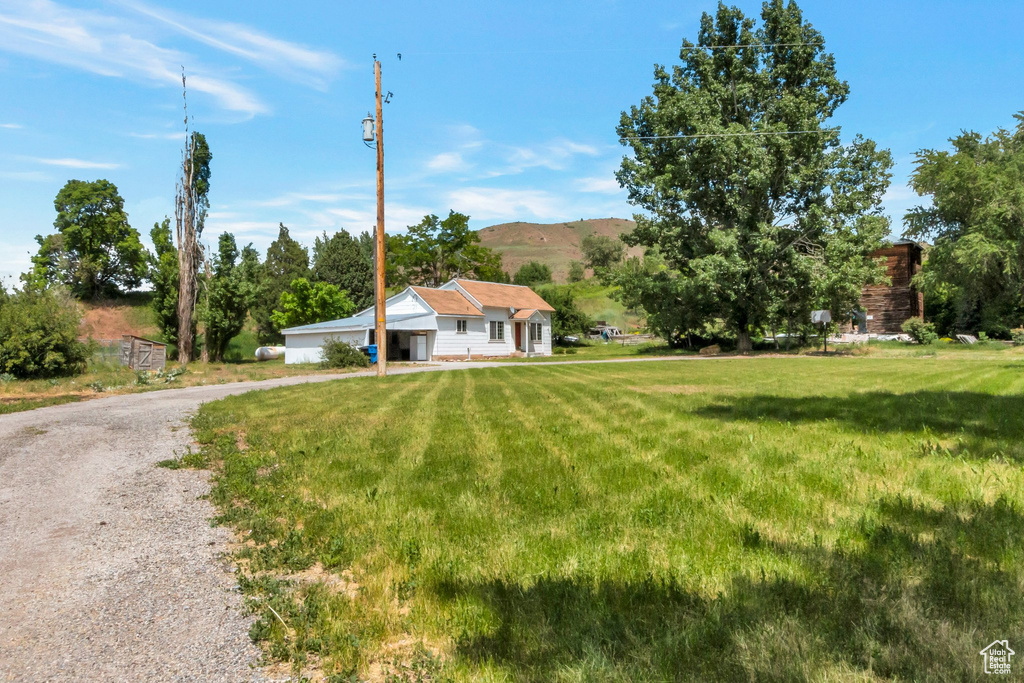 View of front of home with a front lawn, driveway, and a mountain view