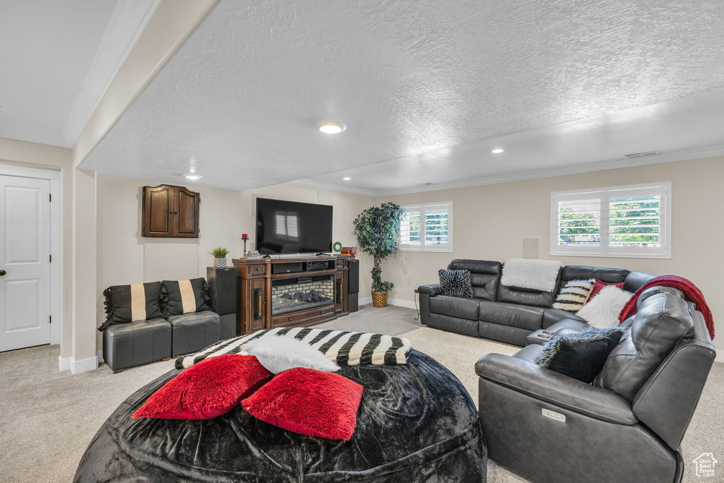 Carpeted living room featuring a textured ceiling, recessed lighting, baseboards, and crown molding