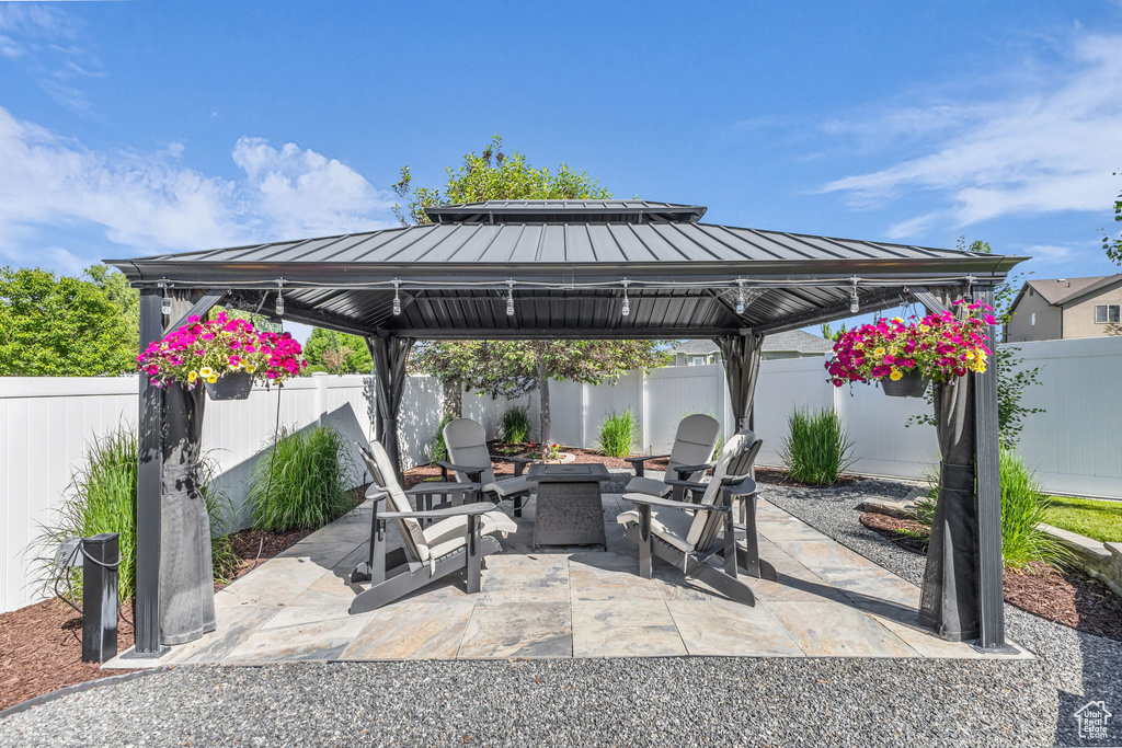 Fenced backyard featuring a gazebo, an outdoor fire pit, and a patio area