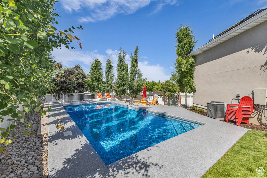 View of swimming pool featuring cooling unit and a patio