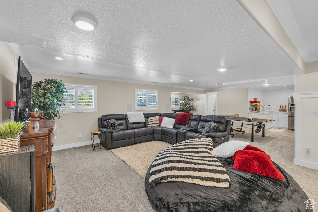 Living area featuring a textured ceiling, light colored carpet, recessed lighting, and baseboards