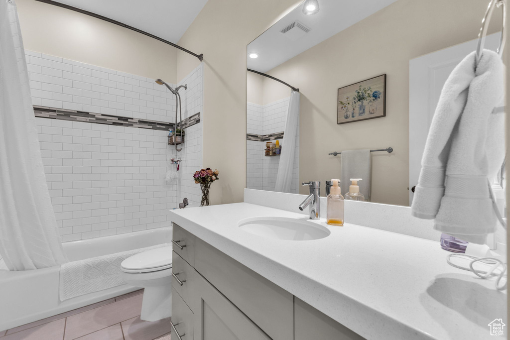 Bathroom featuring vanity, shower / tub combo, toilet, and tile patterned floors