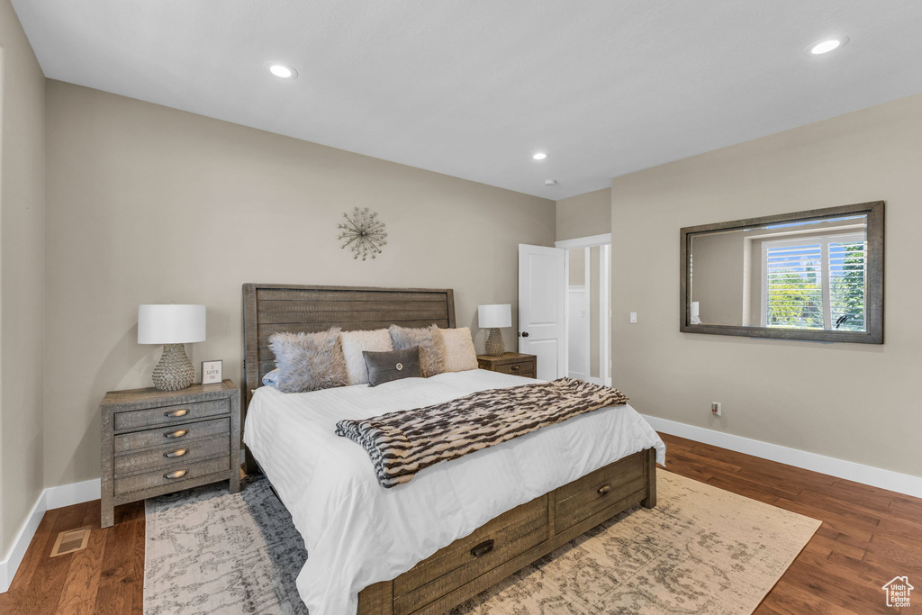 Bedroom with baseboards, wood finished floors, and recessed lighting
