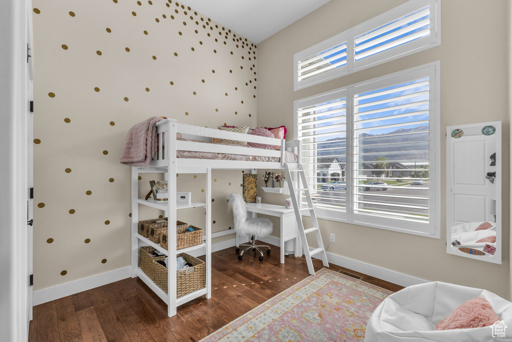 Bedroom with wood finished floors and baseboards