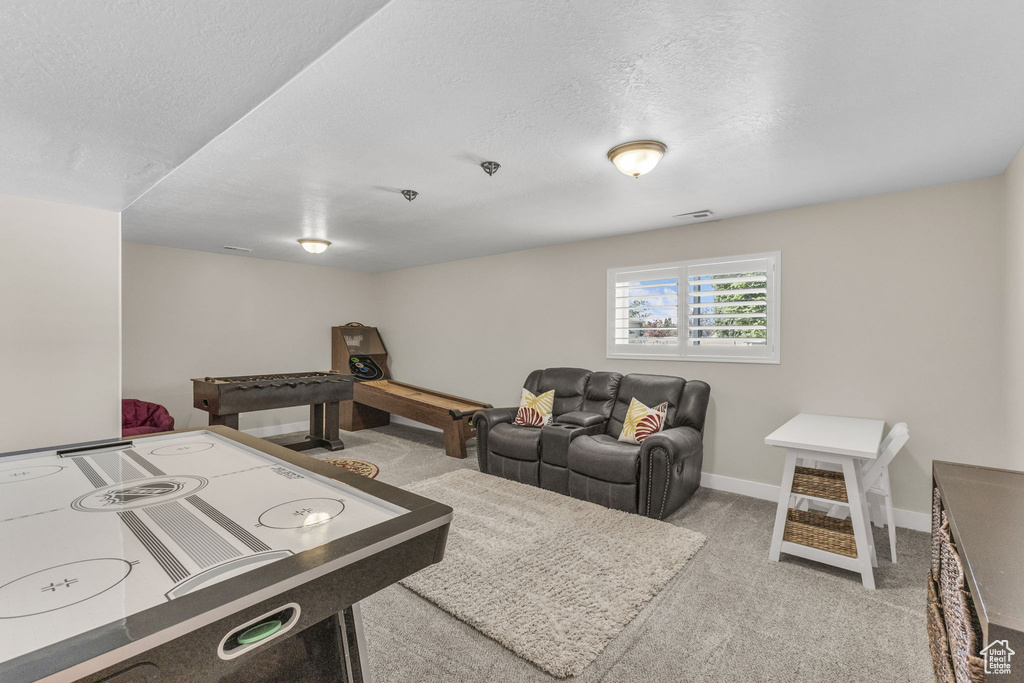 Playroom with a textured ceiling, carpet flooring, and baseboards