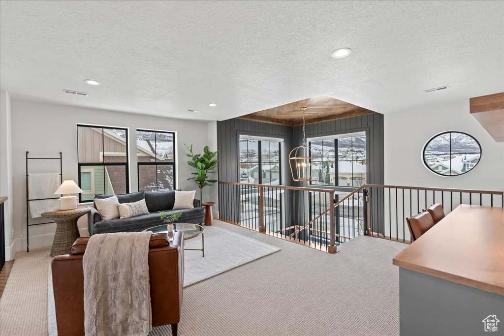 Living area featuring a textured ceiling, carpet floors, and recessed lighting