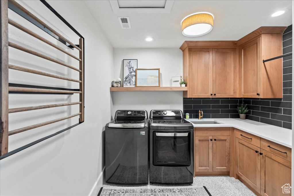 Laundry area with washing machine and dryer, cabinet space, recessed lighting, and baseboards