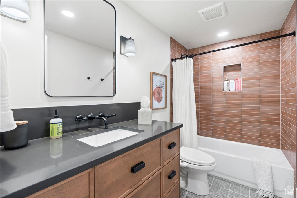 Bathroom featuring tile patterned floors, shower / bath combo, toilet, vanity, and recessed lighting