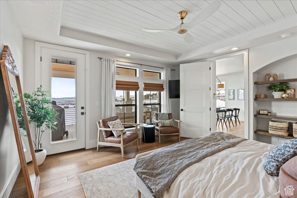 Bedroom with a raised ceiling, access to outside, hardwood / wood-style flooring, wood ceiling, and recessed lighting