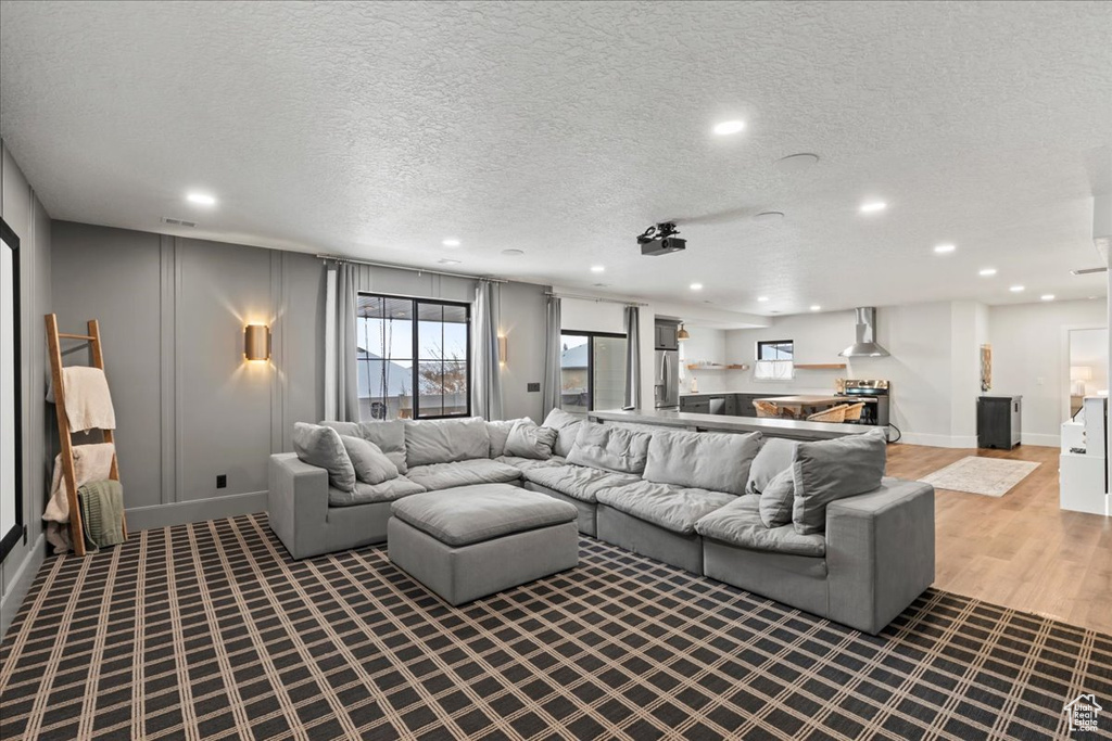 Living area featuring recessed lighting, a textured ceiling, and baseboards