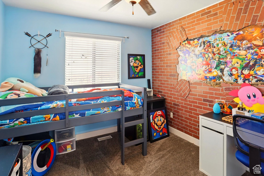 Bedroom with brick wall, carpet flooring, baseboards, and a ceiling fan
