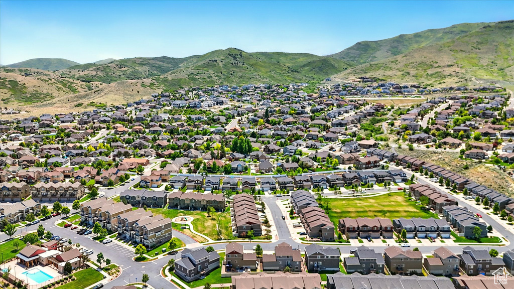 Aerial view of property and surrounding area featuring a mountain backdrop and nearby suburban area
