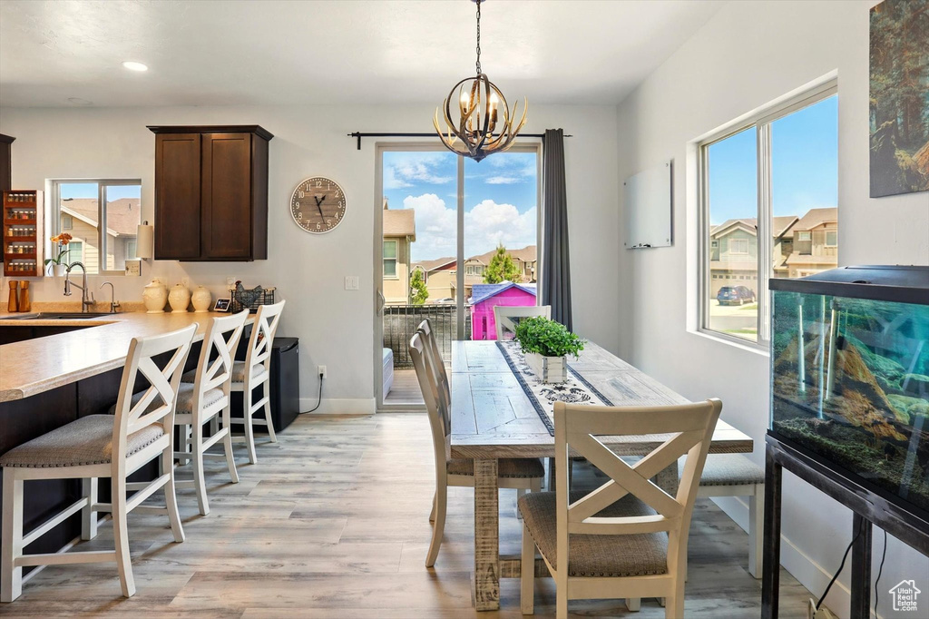 Dining space with a chandelier, light wood-type flooring, recessed lighting, and baseboards
