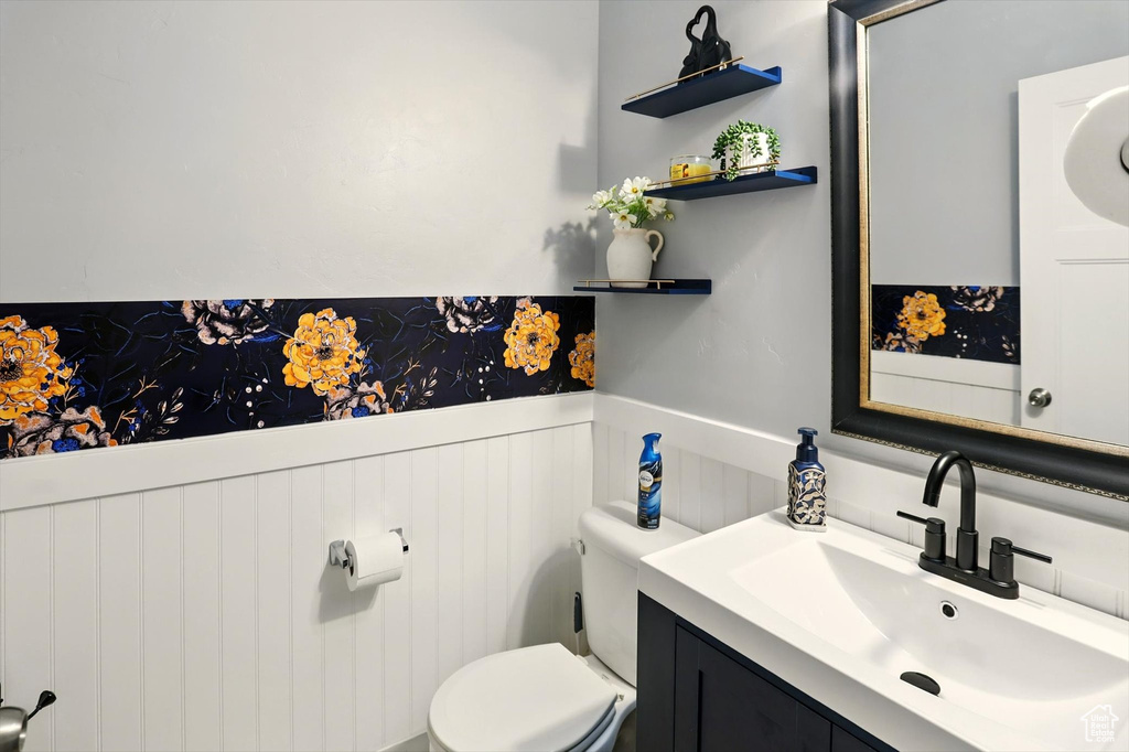 Bathroom with wainscoting, vanity, and toilet
