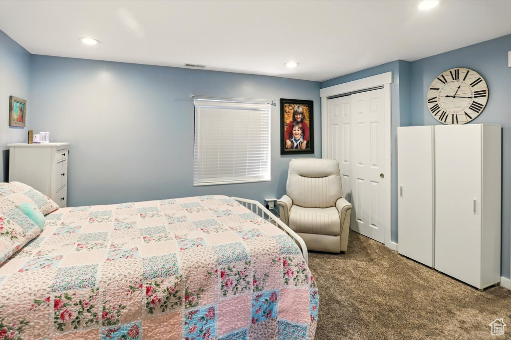 Carpeted bedroom with recessed lighting and a closet