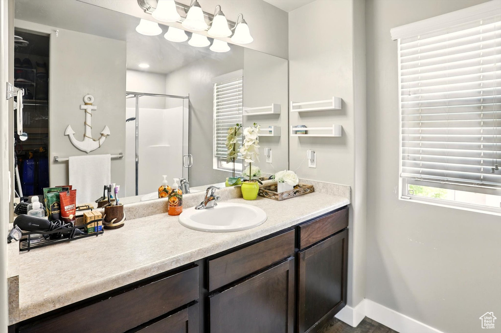 Full bath with vanity, a shower stall, and baseboards