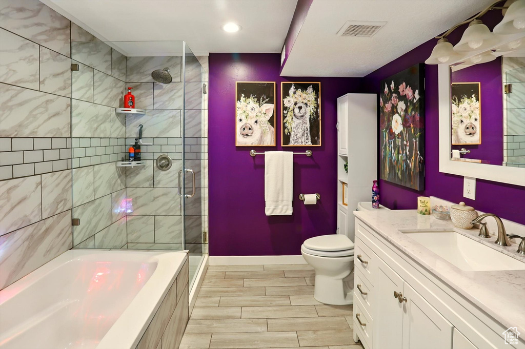 Bathroom featuring a bath, tiled shower, vanity, baseboards, and toilet