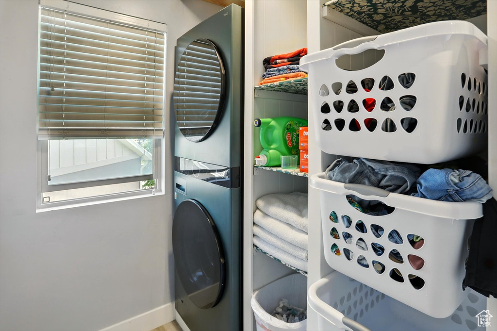 Laundry room featuring stacked washer / drying machine and baseboards