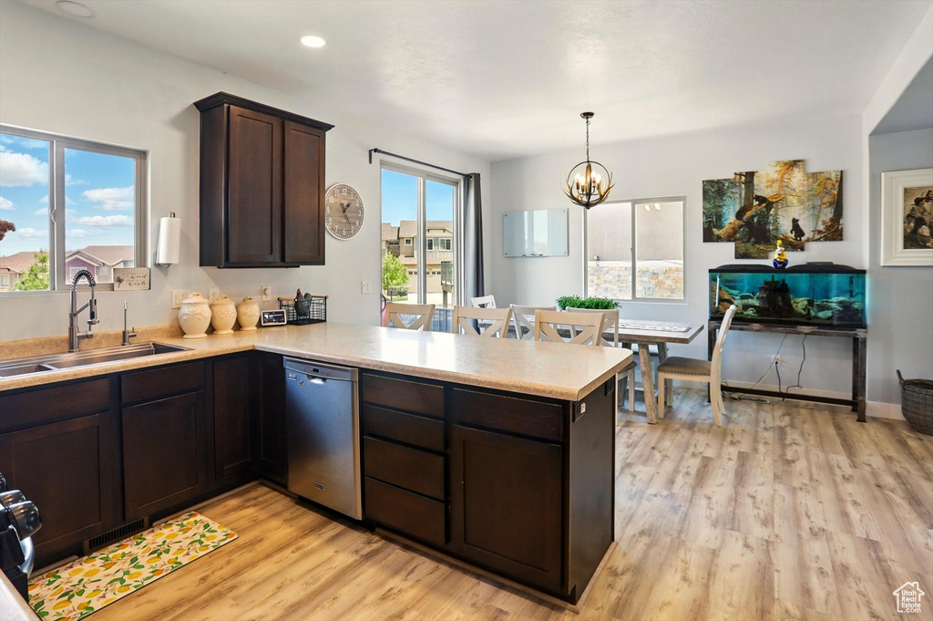 Kitchen with dishwasher, light countertops, light wood finished floors, dark brown cabinets, and a peninsula