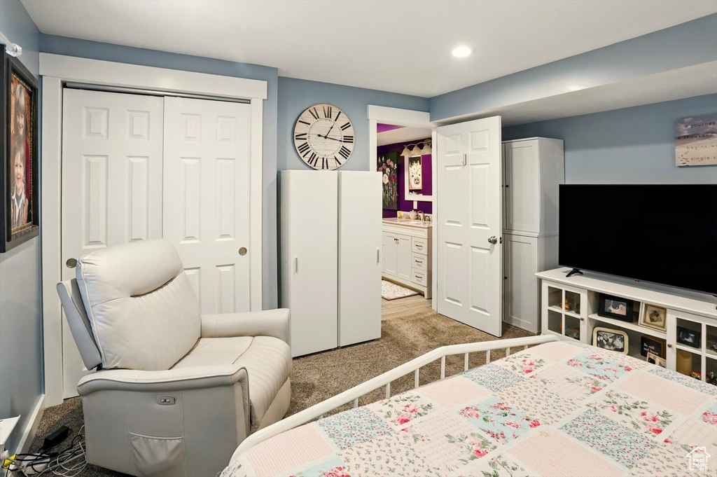 Bedroom with light carpet, a sink, recessed lighting, and a closet
