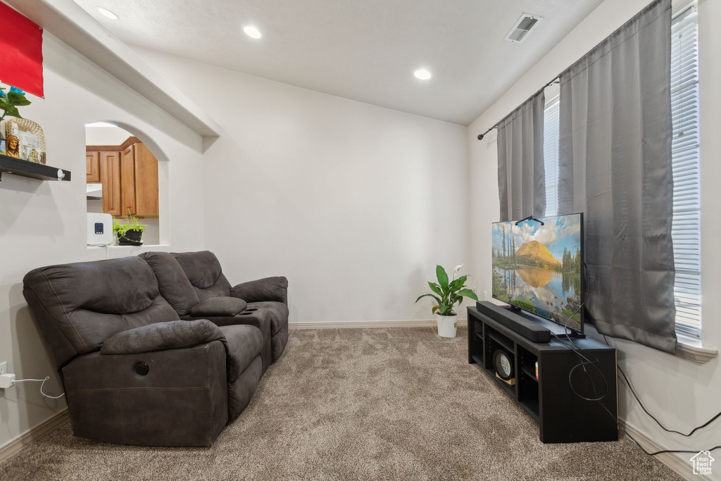 Living area with carpet flooring, recessed lighting, arched walkways, and baseboards