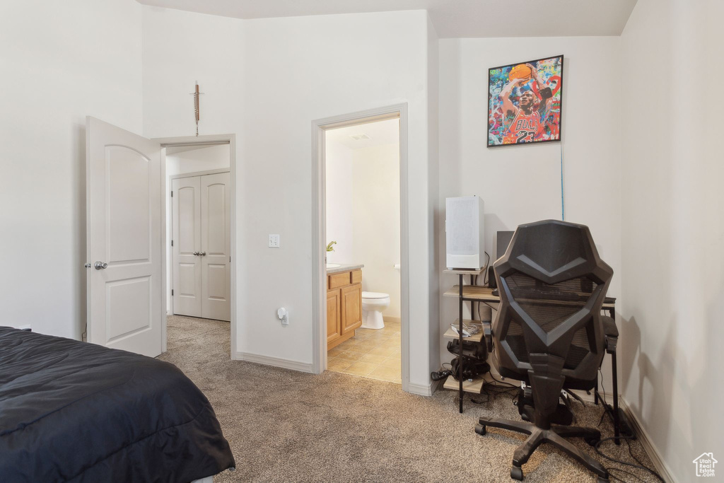 Bedroom featuring light colored carpet, baseboards, and ensuite bathroom