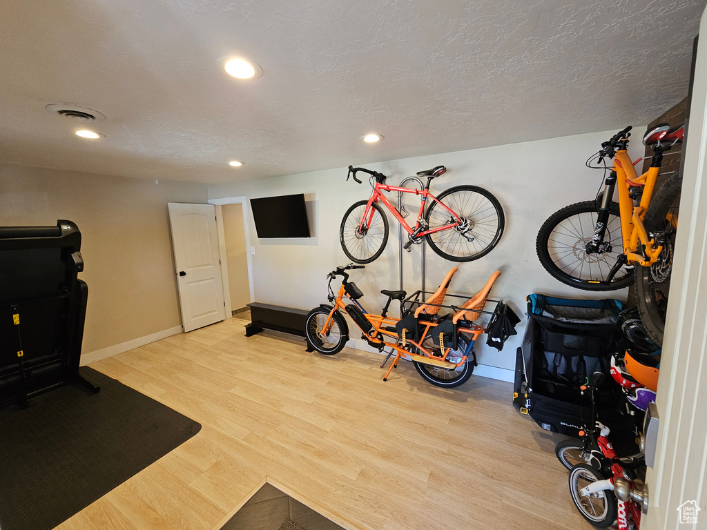 Workout area featuring wood finished floors, recessed lighting, and baseboards