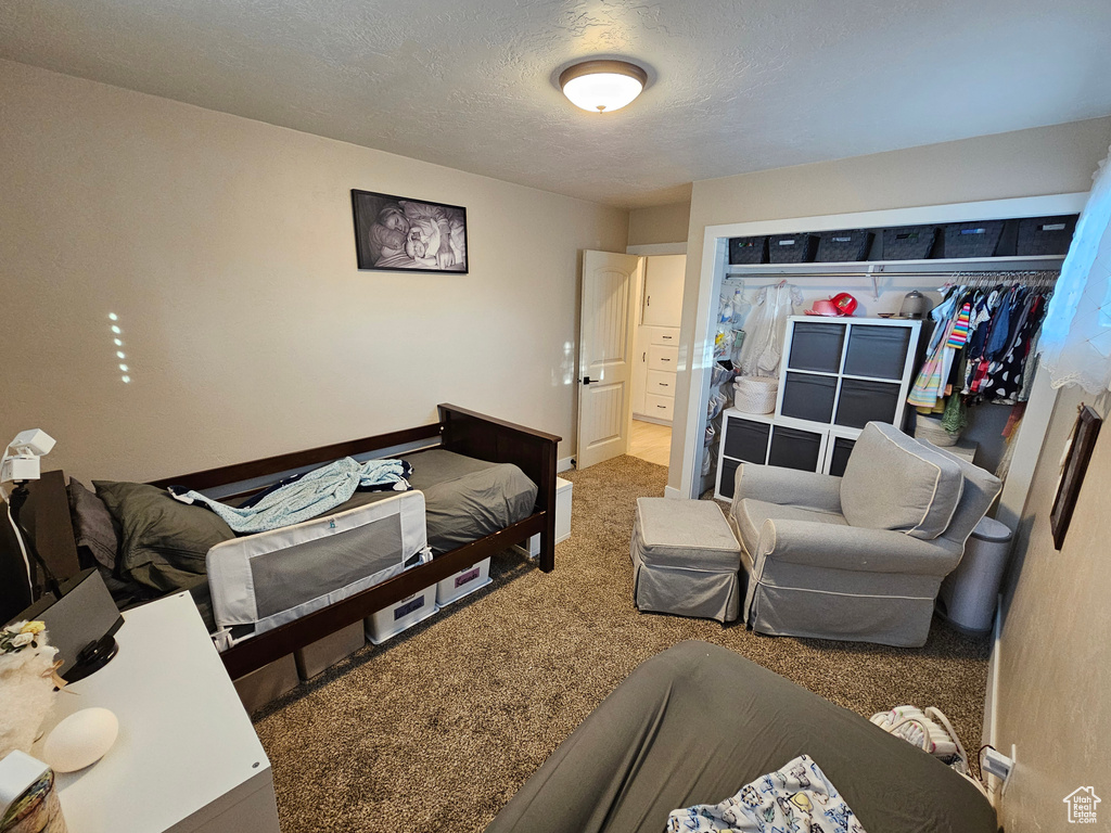 Bedroom featuring carpet flooring and a textured ceiling